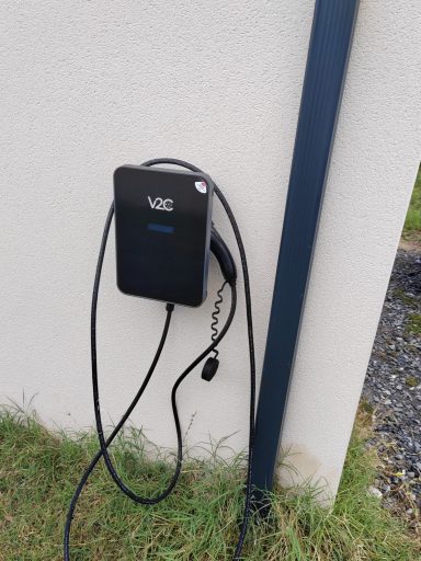 Station de recharge pour véhicule électrique murale avec câble suspendu.