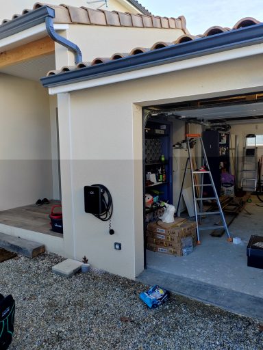 Vue d'un garage avec une échelle, des boîtes et des outils à l'extérieur.