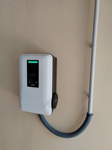 Chargeur électrique mural avec un écran et un câble gris.